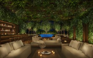 relaxed seating under planted ceiling and walls next to the roof top swimming pool at The Singapore EDITION