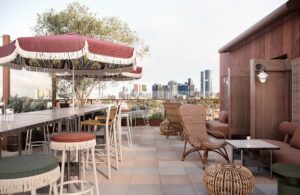 Bar stools and umbrellas with fringes on the rooftop terrace