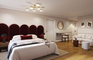 large hotel guestroom with art deco style velvet headboard, white couch and wooden floors