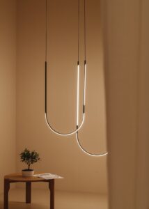 neutral walls with wooden table as backdrop for statement Tubs modular lighting in a curve from ceiling