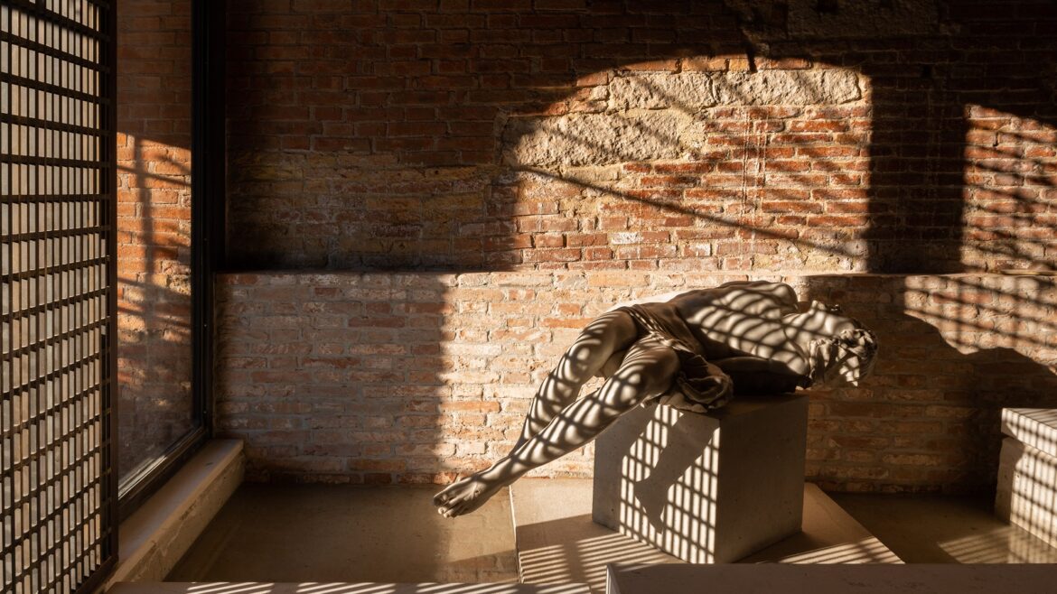 sunlight through window of Venice Venice hotel onto brick wall and reclining statue