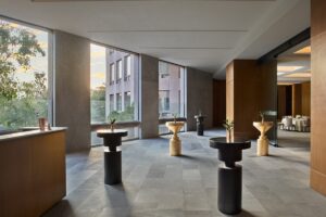individual sculptural standing tables spaced out in the hotel lobby