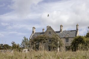 external view across grassland of Lundies House in Scotland