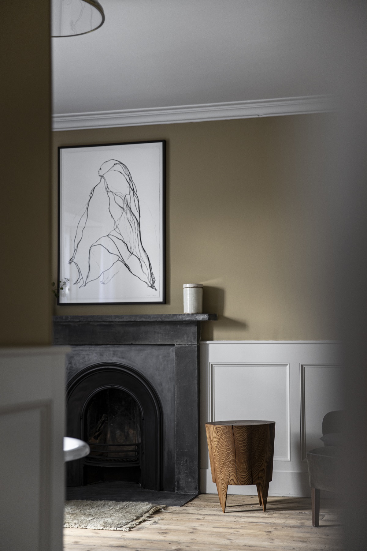 black fireplace, modern artwork, minimal wooden stool