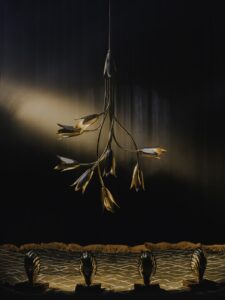 sculpted metal flowers form a chandelier against a dark velvet backdrop