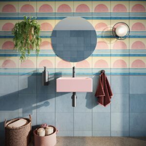 pink and blue patterned bathroom tiles with pink basin and round mirror