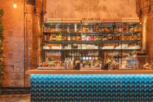 back lit bar against exposed stone work with blue tiles bar frontage