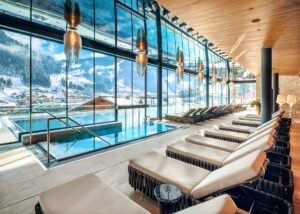loungers next to an indoor outdoor spa pool in the alps