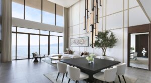 white living room in ocean front villa with floor to ceiling glass wall overlooking ocean