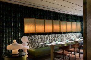 banquette seating in green in front of backlit wall feature in Basilico restaurant