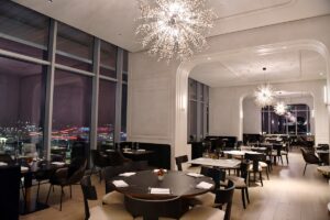 statement chandelier above wooden dining tables in restaurant in Signia by Hilton Atlanta