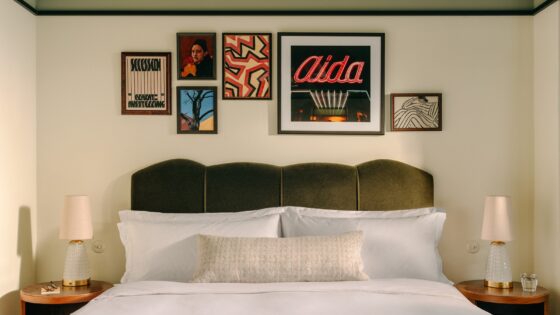 guestroom in The Hoxton Vienna with velvet upholstered headboard and art gallery on the wall