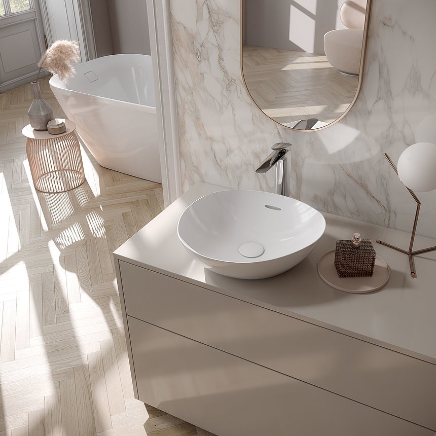 white freestanding bath behind marble wall and vanity with touchfree tap