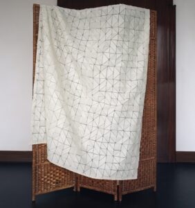 cut and textured fabric from Dedar hung over bamboo screen