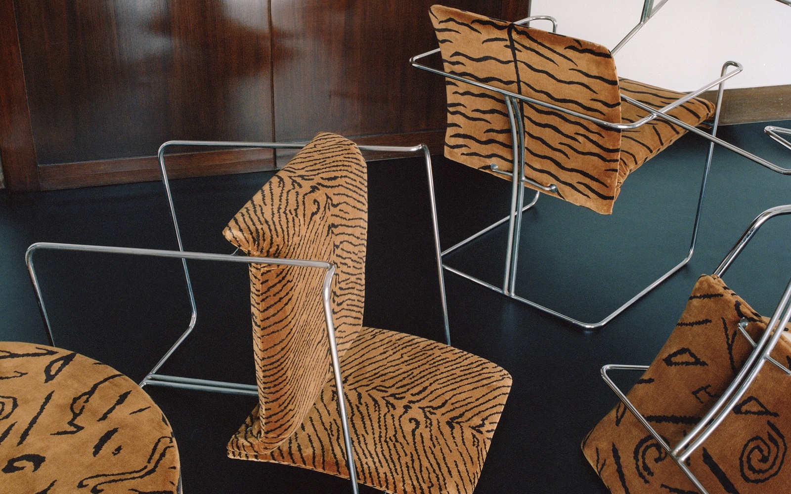 a collection of wire framed chairs in different patterns of Dedar tiger fabric
