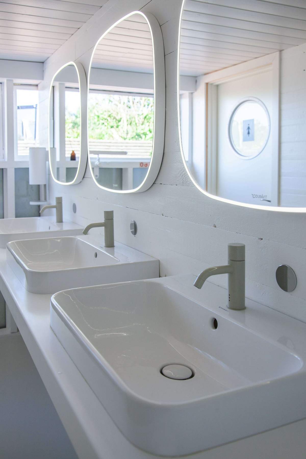 bathroom in white beach hut with above-counter basins of the Happy D.2 Plus range, Zencha’s gently rounded mirrors