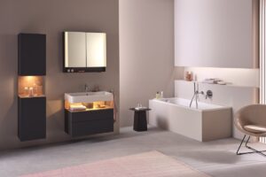 brown and cream bathroom with backlit shelving niches, bath and chair