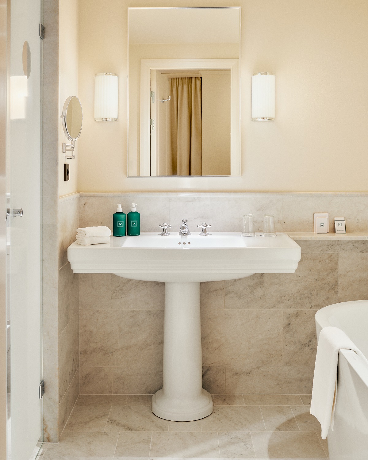 white cream and marble hotel bathroom with art deco elements