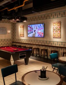 pool table, seating and digital art by Betty Leung on the wall