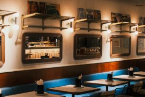 blue banquette seating with mirrors , lighting and art work above