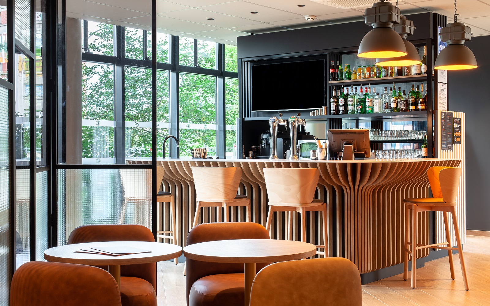 bar with wooden chairs and industrial style lighting in B&B HOTELS Paris
