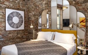 mirrored headboard in guestroom contrasting with stone walls