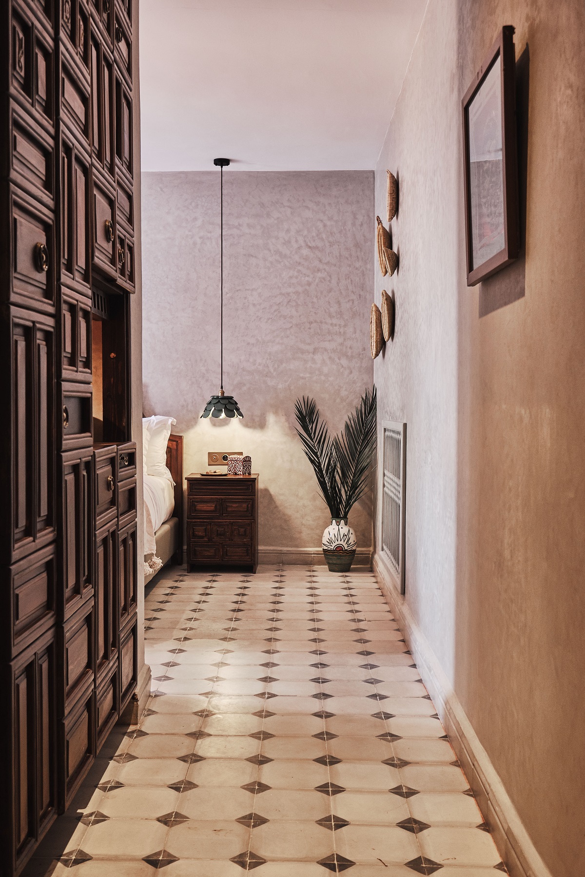wooden moroccan door leading into guestroom with tiles pattern on the floor