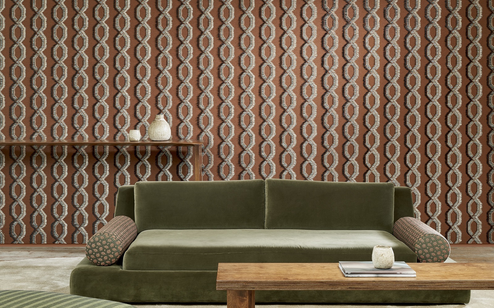low green velvet couch and wooden coffee table in front of patterned Arte wallcovering from Le Couturier collection