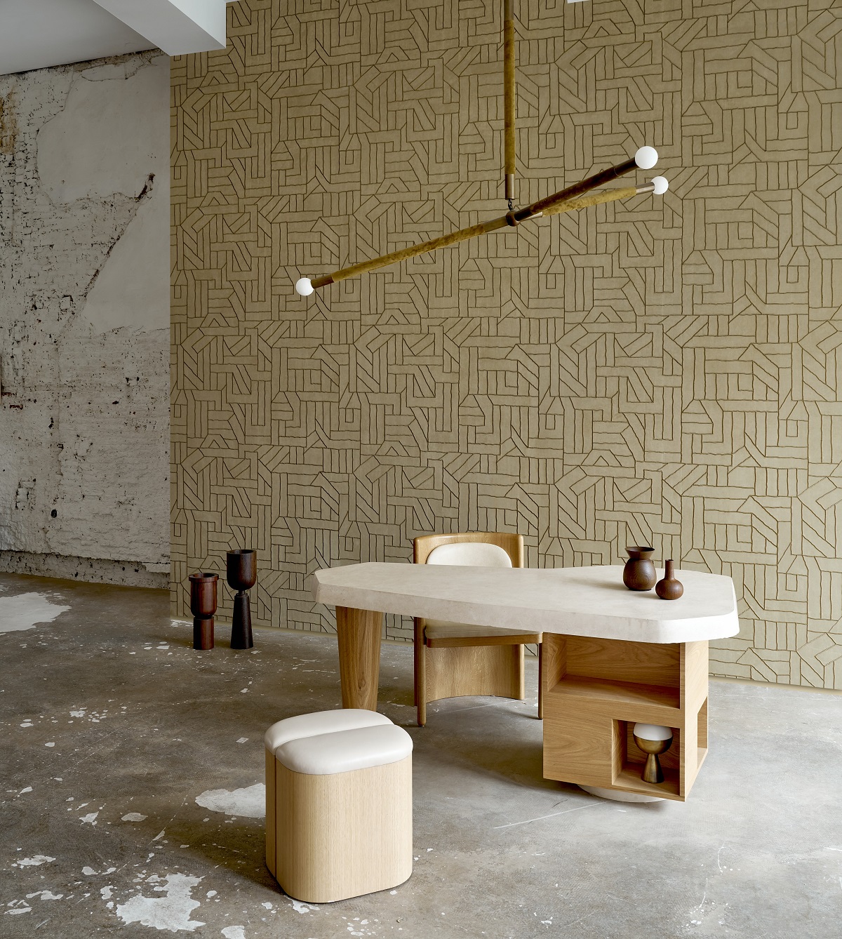 table and chair under architectural light in front of embroidered arte wallcovering