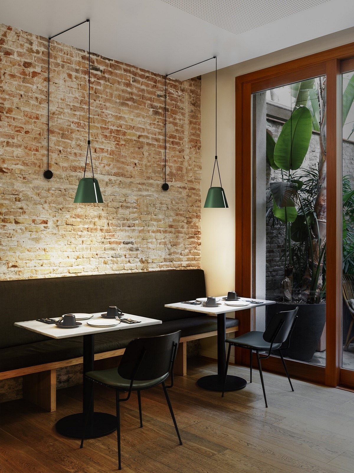 restaurant tables against exposed brick wall with Attic lights above