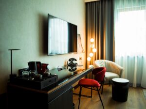 desk in Radisson hotel guestroom with red desk chair and white lounging chair by wndow