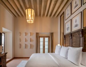 hotel guestroom with plaster walls, high ceilings and wooden beams