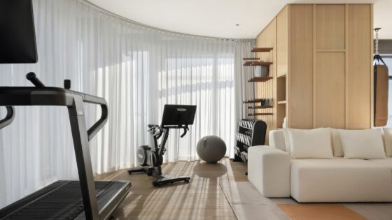 guestroom in Siro with white couch and gym equipment on wooden floor