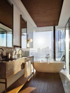 the Paris bathroom in The Lana Dubai with views across the city from floor to ceiling windows by the bath