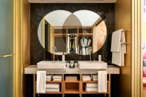 double basin below double round mirror in guestroom at The BoTree London