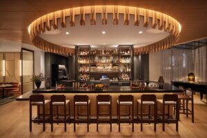 central square bar with round overhead panel and wood detail by AvroKO