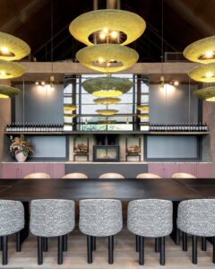 bar with seating and wooden bar counter below handwoven lighting by Studio Lloyd