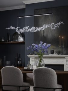 suspended sculptural blossom light above dining table and vase of flowers