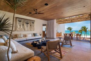 open plan lounge with doors onto beach and natural textures and colours in the design