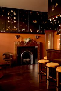 burnt orange walls with decorative panelling in the bar of Hotel Bellevue London