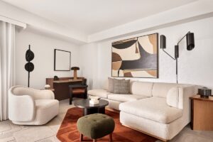 lounge area in hotel guestroom with curved couches and mid century design elements