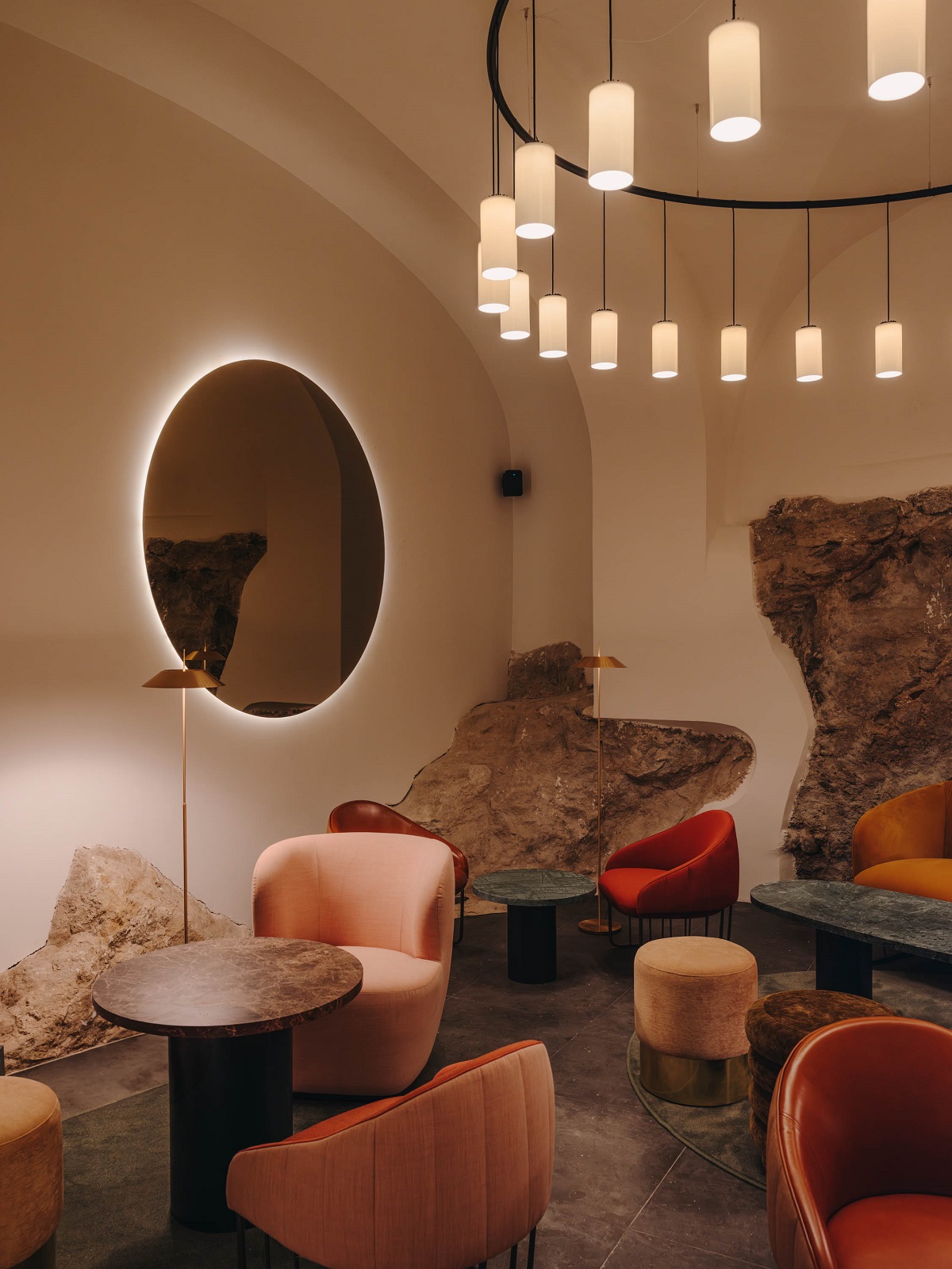 round statement light, round mirror and chalk coloured furniture with round edges
