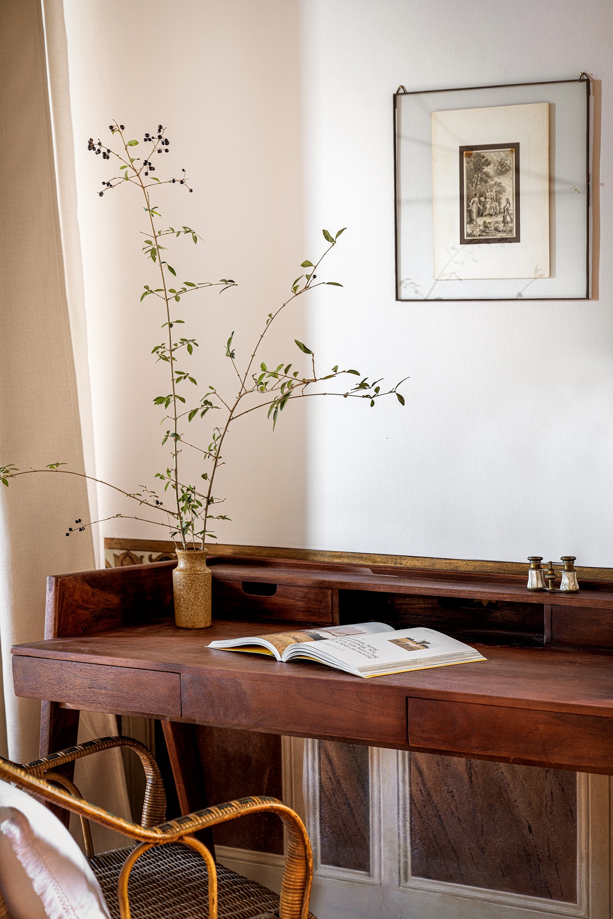 wooden desk, flowers and an open book in hotel guestroom