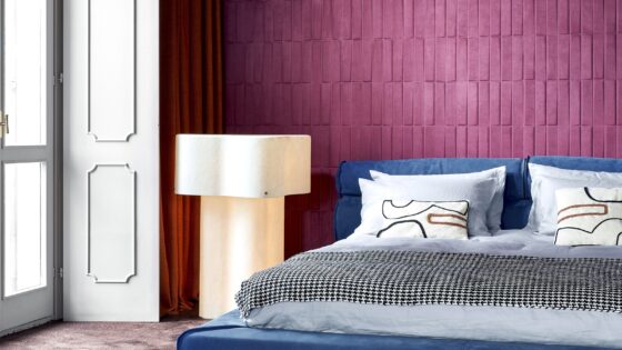 aubergine wall covering from Arte behind bed in grey and blue
