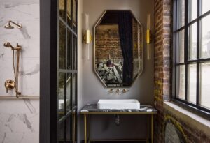 industrial style hotel bathroom with art reflected in the mirror