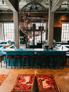 turquoise bar in centre of industrial style hotel space
