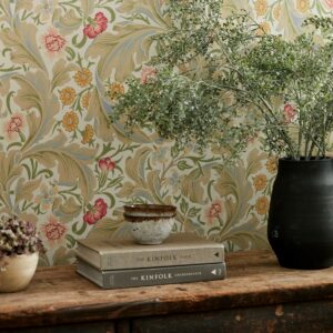 flowers and books on a shelf with floral wallpaper in background