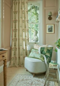cream chair backed with botanical Morris print in front of window