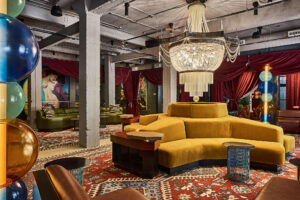 central velvet sofa under chandelier with graffiti on the walls in The Radical