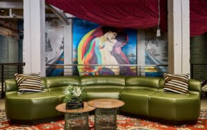 green curved sofa in front of graffiti style art in the lobby of The Radical